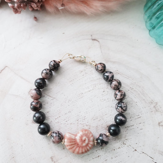 Black striped agate bracelet with pink ceramic ammonite charm